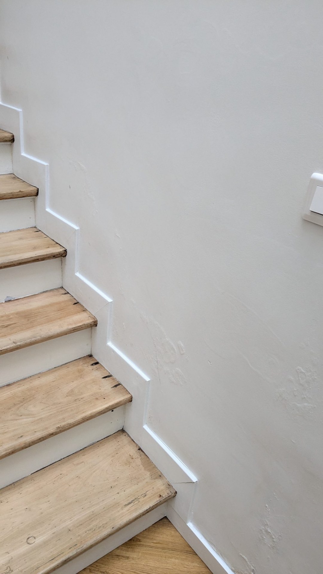 Trace d'humidité au pied d'un mur d'escalier intérieur